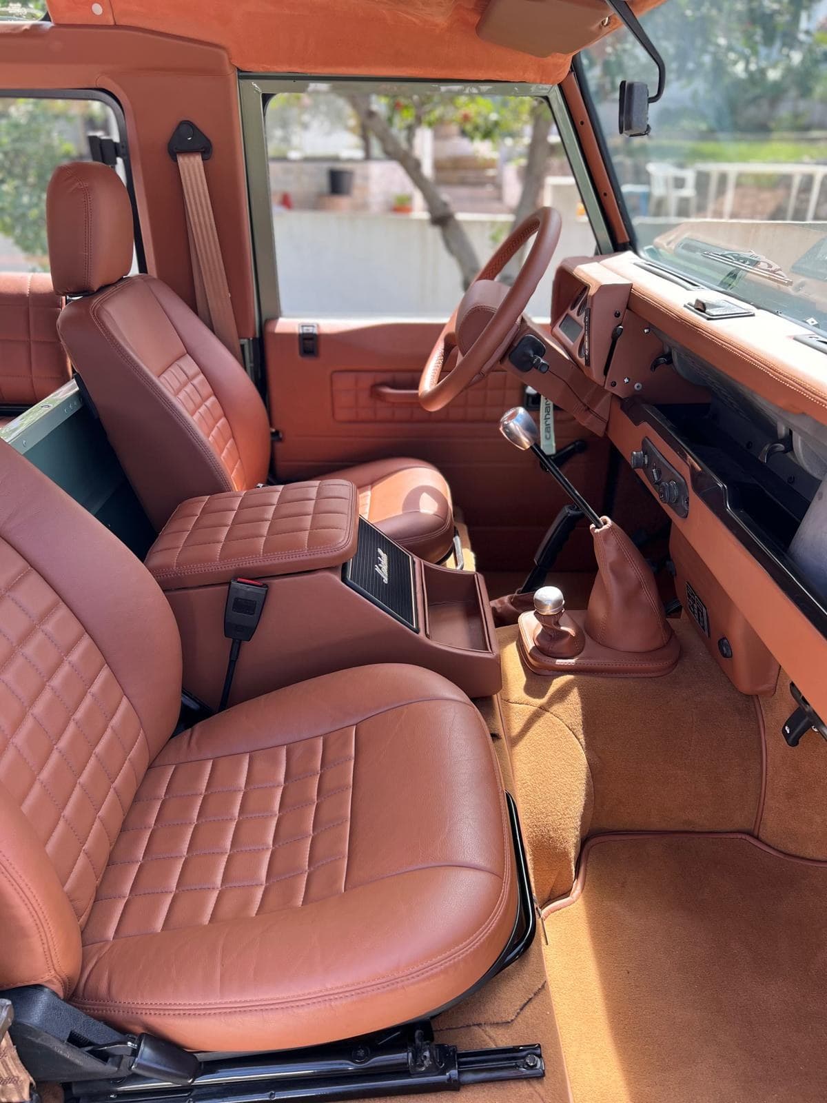 Interior of the Land Rover Defender Heritage — tan leather seats and wood dash